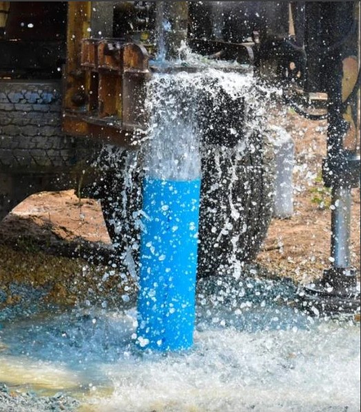 Limpeza de poço artesiano com água jorrando